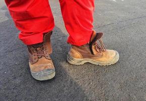 des agents de sécurité et de l'environnement en bonne santé qui portent des pantalons rouges et des chaussures de sécurité marron. photo