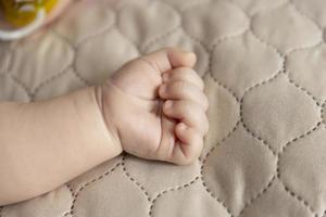 main d'un bébé allongé sur le lit. gros plan de la paume. concept de la paternité et de la fête des enfants. photo