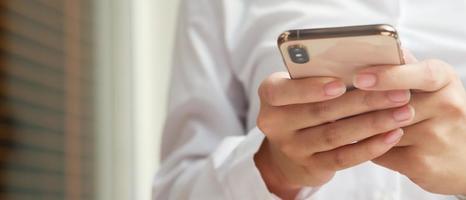 gros plan main jeune femme en regardant le message sur le téléphone intelligent mobile pendant la pause. utiliser des téléphones portables pour communiquer dans le monde en ligne. avec écran noir vierge ou vide photo