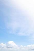 beau fond de ciel bleu clair avec un petit nuage blanc uni sur les rayons du soleil du matin. espace pour le texte. mise au point douce. photo