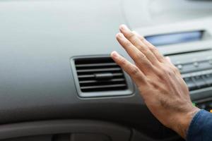 gros plan sur un conducteur manuel vérifiant le réglage de l'air provenant du conditionnement du système de refroidissement avec un flux d'air froid dans la voiture. laisser de la place pour écrire du texte. photo