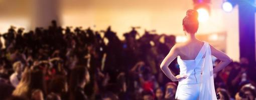 une femme se tient devant la caméra de télévision de la presse médiatique en tant que modèle de défilé de mode ou rate le concours de la reine de beauté pour responsabiliser les gens, vue arrière d'une femme méconnaissable photo