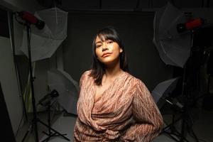 femme indienne asiatique montre un beau sourire lèvres heureuses, poses de mode en studio photo avec équipement