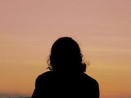 silhouette d'une personne sur le fond du coucher du soleil photo