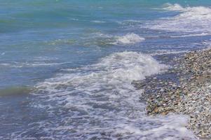 les vagues de la mer courent vers le rivage de galets. plack ligne de côte de la mer photo