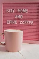 tasse à café rose et qoute restez à la maison et buvez du café. campagne d'auto-isolement et de quarantaine. photo