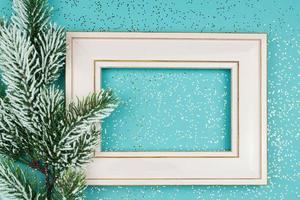 carte de voeux festive pour noël avec cadre photo, branche d'épinette sur fond de confettis bleus. photo