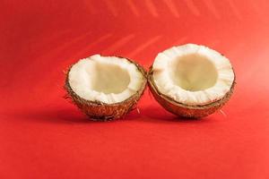deux moitiés de noix de coco crue fraîche sur fond rouge. photo