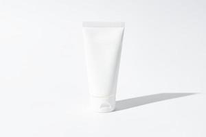 maquette de tube en plastique de bouteille de compression blanche pour la marque de médicaments ou de cosmétiques - crème, gel, soins de la peau, dentifrice. contenant de bouteille cosmétique sur un fond blanc avec des ombres. minimalisme photo