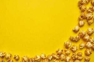 gros plan de pop-corn au caramel doré. fond jaune de pop-corn. collations pour un film photo