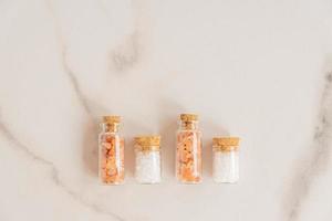 concept d'aliments sains sel de l'himalaya rose et sel de mer dans des bocaux en verre sur fond de marbre photo