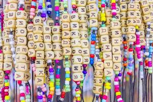 bracelets faits à la main avec des noms russes dans une boutique de souvenirs. fond coloré photo