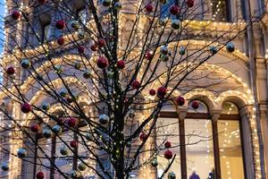 fond de vacances de noël et du nouvel an. arbre sans feuilles décoré de boules rouges et or. photo