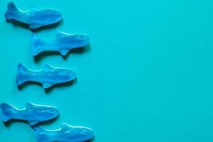 vue de dessus de bonbons à la gelée bleue. délicieuse marmelade. bonbons en forme de poisson sur fond bleu avec espace de copie photo