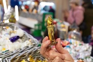 main féminine tenant dans le magasin une bougie jouet, décoration de noël. préparation des vacances photo