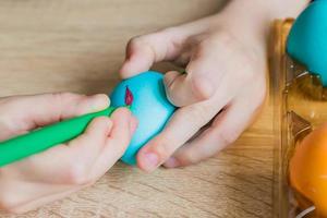 main d'enfant peignant un oeuf de pâques avec un stylo-feutre. fermer photo