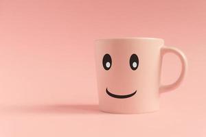 tasse rose sur fond rose. visage souriant sur une tasse. concept créatif minimal photo