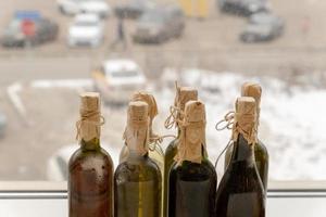 des bouteilles de vin poussiéreuses sont posées sur le rebord de la fenêtre. photo