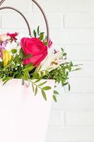 fleurs dans une boîte cadeau de luxe rose. bouquet de fleurs dans une boîte en papier. décoration intérieure aux couleurs pastel. photo