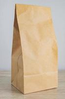 gros plan sur un sac en papier blanc artisanal pour la livraison de nourriture. maquette pour les concepteurs. concept d'achat et de livraison photo
