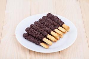 Snack food biscuit stick enrobé de chocolat sur bois blackground photo