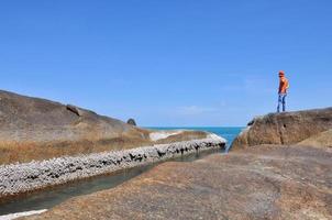 homme debout sur les rochers, la mer et le ciel bleu de l'île de samui en thaïlande photo