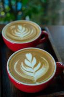 deux cafés latte art dans une tasse rouge photo