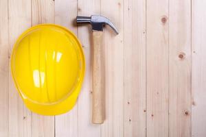 Marteau et casque jaune sur fond de bois photo