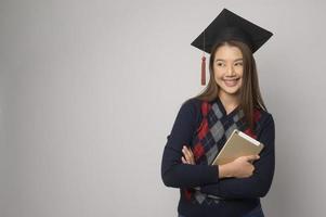 jeune femme souriante tenant chapeau de graduation, concept d'éducation et d'université photo