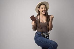 jeune femme touristique asiatique heureuse sur fond blanc concept de studio, de voyage et de vacances. photo