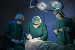 groupe de chirurgiens professionnels métis opérant dans la salle d'opération de l'hôpital, concept de soins de santé. photo