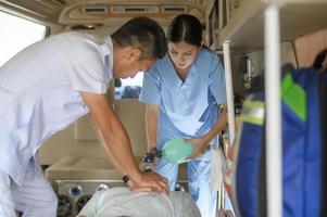 groupe d'équipe d'urgence de sauvetage transportant le patient de la voiture d'urgence à travers les couloirs de l'hôpital. réanimation cardio-pulmonaire chez un patient inconscient. photo