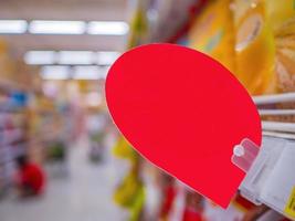 maquette d'une étiquette de réduction rouge vierge sur les étagères des produits du supermarché photo