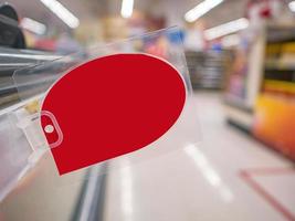 maquette d'une étiquette de réduction rouge vierge sur les étagères des produits du supermarché photo