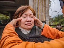 les femmes asiatiques âgées se font masser la tête par son amie photo