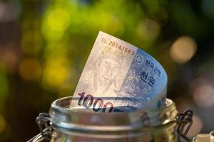 billets de corée du sud dans un bocal en verre. photo