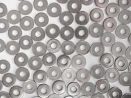 De nombreuses rondelles plates en acier inoxydable sur fond gris clair photo