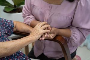 tenant par la main une vieille dame asiatique ou âgée patiente avec amour, soins, encouragement et empathie dans la salle d'hôpital de soins infirmiers, concept médical solide et sain photo