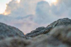 gros plan de rock flou au premier plan avec le ciel nuageux. photo