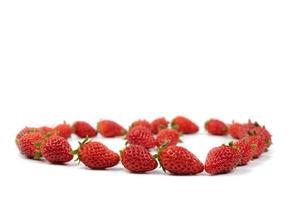 des fraises de luxe fraîches sont perturbées dans la zone de groupe avec une lumière de studio sur fond blanc. photo