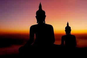 silhouette de bouddha sur fond de coucher de soleil doré croyances du bouddhisme photo
