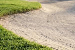 Le fond de beauté du bunker de bac à sable est utilisé comme obstacle pour les tournois de golf pour la difficulté. et décorer le terrain pour l'herbe beauty.green avec une texture de sable. photo