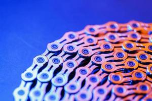 la texture d'une chaîne de vélo brillante avec un rétroéclairage bleu-violet photo