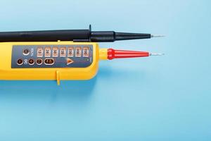 testeur jaune pour l'indication étape par étape de la tension dans un circuit électrique sur fond bleu photo