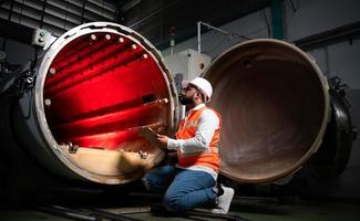 l'ingénieur en chef de l'usine mécanique effectue l'inspection du tunnel de la machine de stérilisation. vérifier l'état de fonctionnement de la machine pour être prêt photo