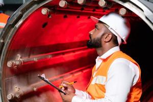 l'ingénieur en chef de l'usine mécanique effectue l'inspection du tunnel de la machine de stérilisation. vérifier l'état de fonctionnement de la machine pour être prêt photo