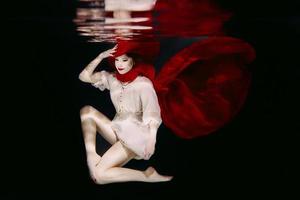 femme au chapeau rouge et écharpe rouge sous l'eau photo