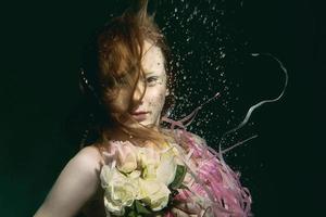 jeune fille rousse en robe faite de roses sous l'eau photo