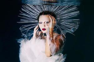 belle femme aux lèvres rouges et aux bijoux féminins sous l'eau comme la vierge marie photo