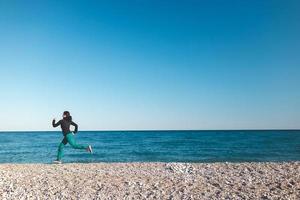 une fille sur un jogging matinal sur la plage photo
